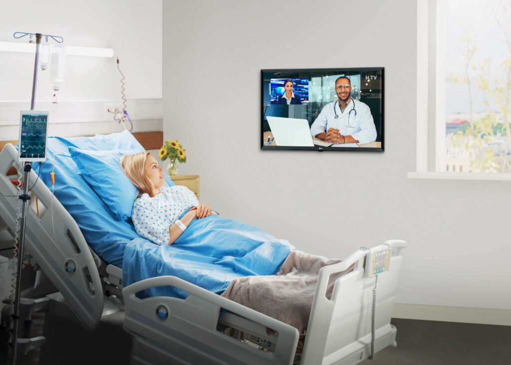 Patient watching educational content on an LG modular TV in a hospital room.