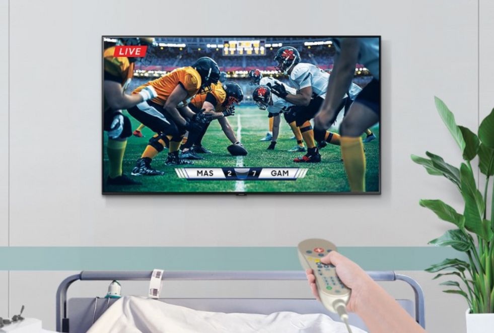 Hospital Patient Watching Football IPTV Hospital patient watching a football game on a smart TV with IPTV for hospitals, providing comfort and entertainment during their stay.