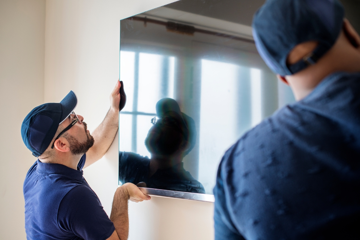 Pro Services MDM installation team staging and installing commercial-grade TVs in a hotel guest room.