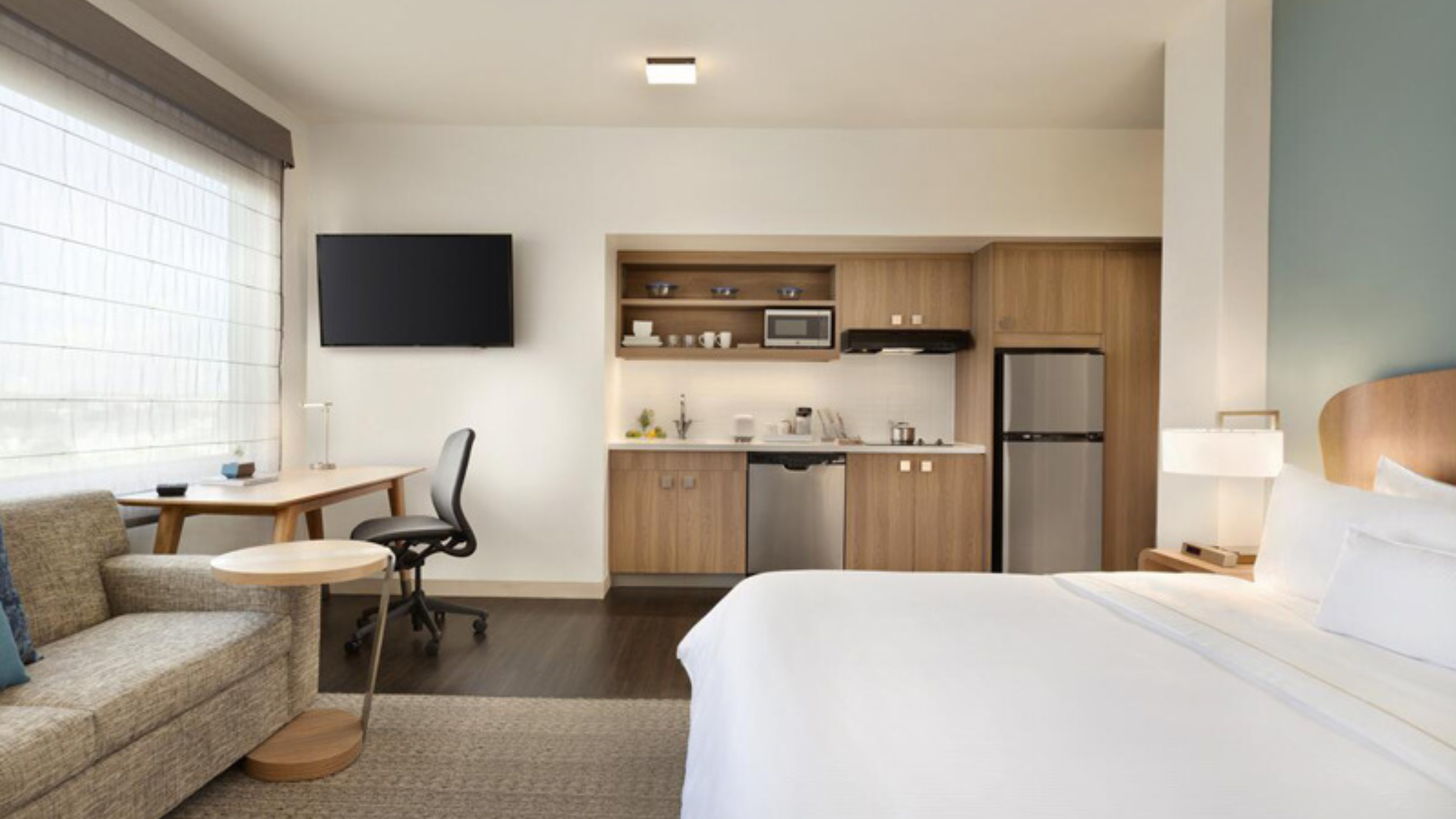 Modern guestroom with a hotel mini refrigerator, microwave, and casegoods supplied through MDM Commercial’s single-source FF&E program.
