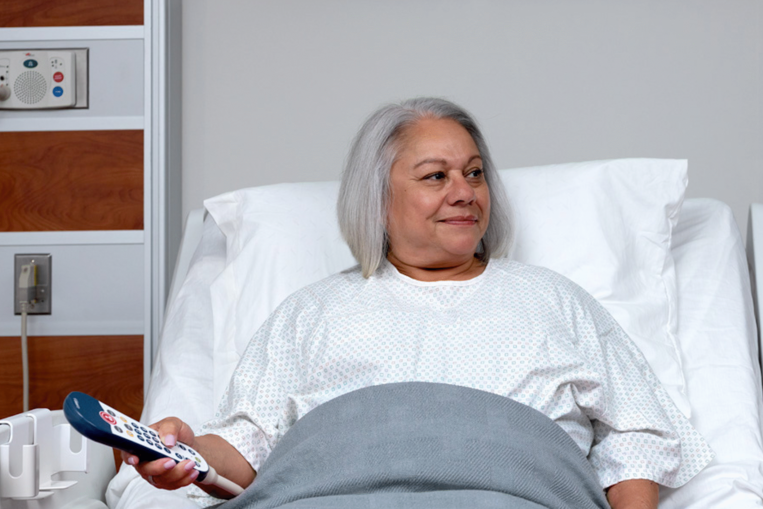 Hospital bedside remote and pillow speaker used for patient TV control and nurse call access