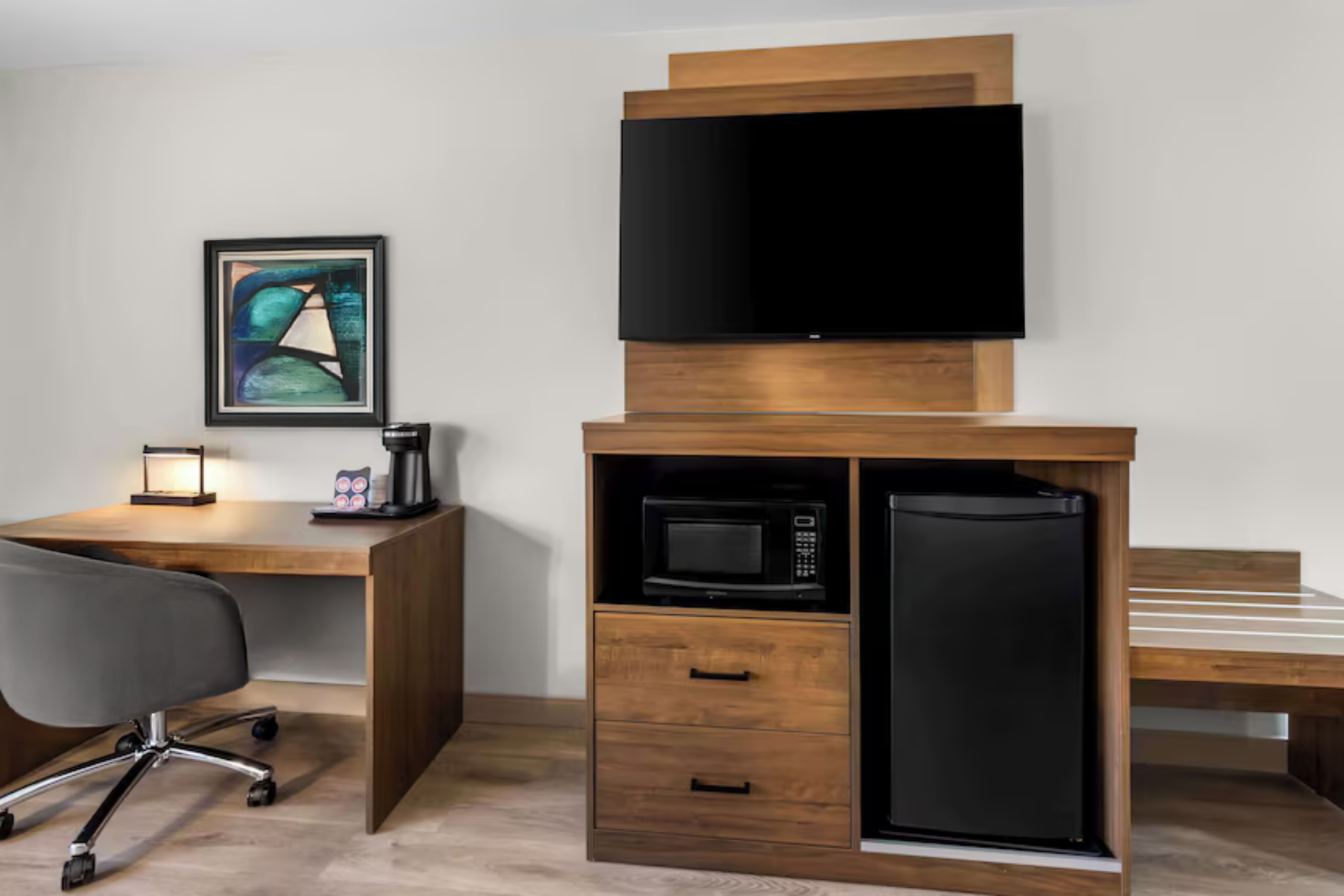 “Best Western hotel guest room featuring LG hospitality TV, mini refrigerator, microwave, and modern guest room furnishings.”