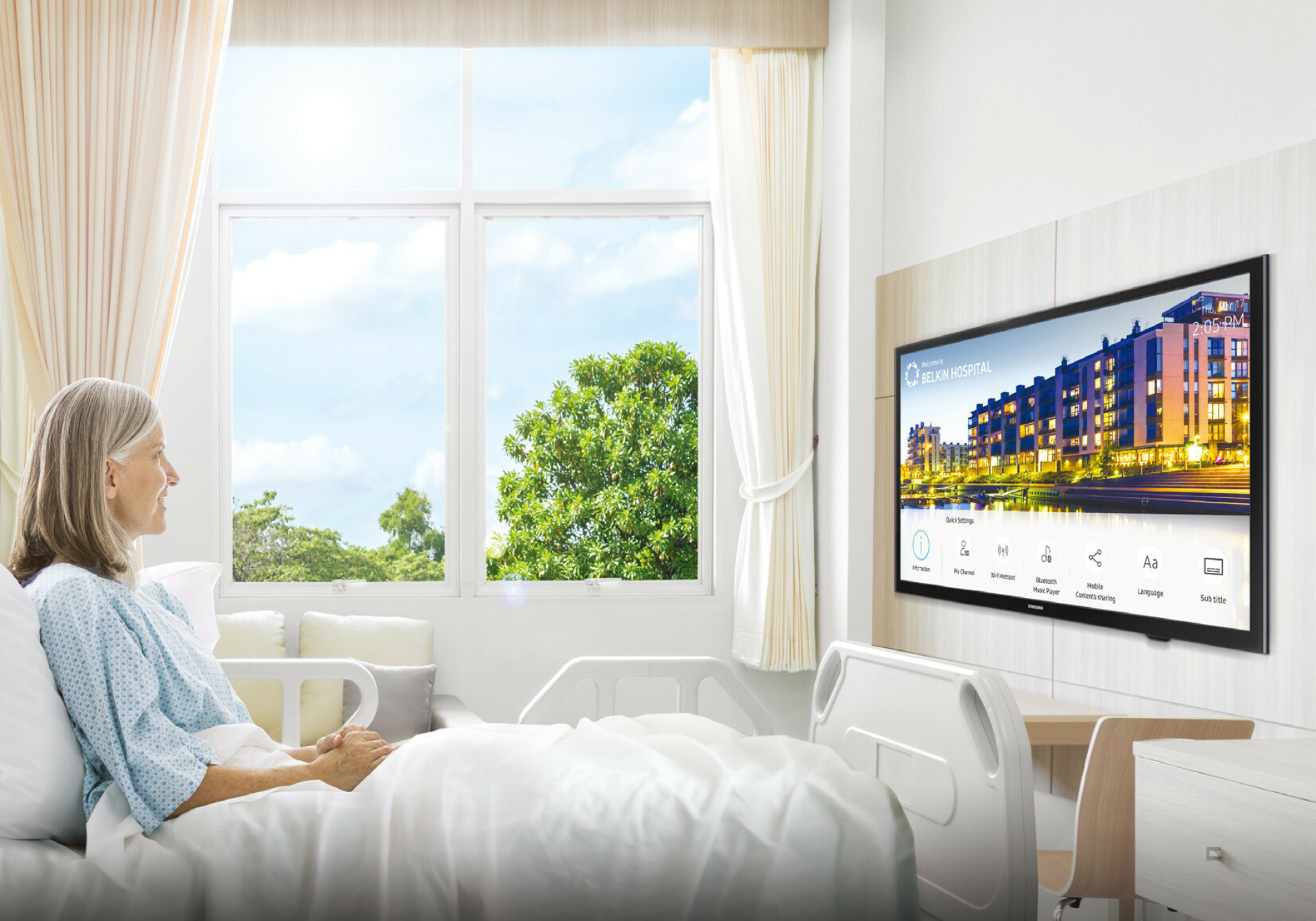 Patient in hospital room watching hospital TV with wall-mounted healthcare display and modern patient entertainment system.