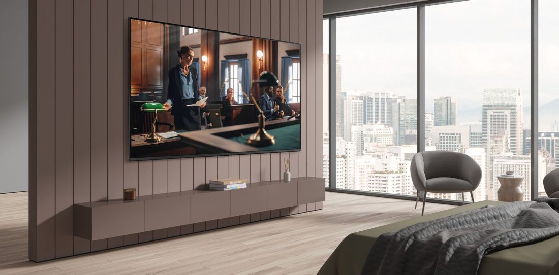 Modern hotel guest room featuring a wall-mounted LG TV, contemporary furnishings, and floor-to-ceiling windows overlooking a city skyline.